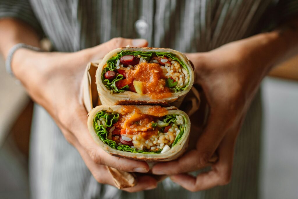 A person holding a burrito with both of their hands