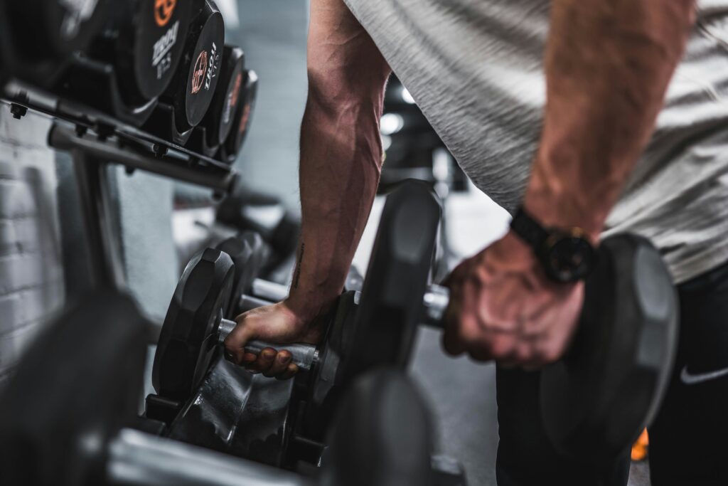 Person lifting a dumbbell at a gym.