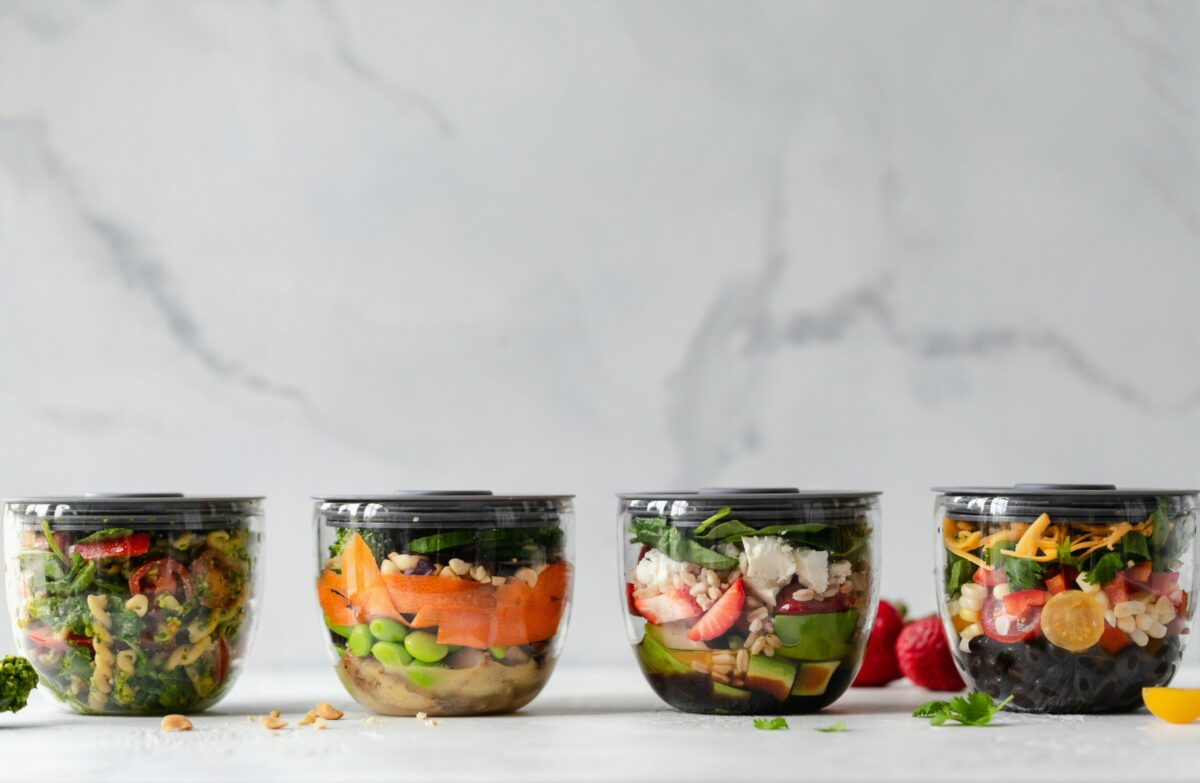 Four colorful meal-prep salad bowls arranged in a row